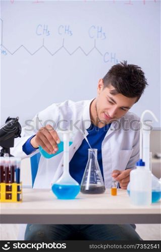 Young chemist sitting in the lab 