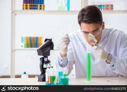 Young chemist student working in lab on chemicals