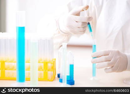 Young chemist student working in lab on chemicals