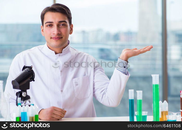 Young chemist student working in lab on chemicals