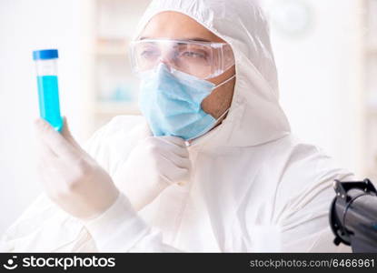 Young chemist student working in lab on chemicals