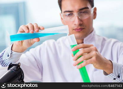 Young chemist student working in lab on chemicals