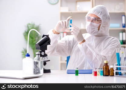 Young chemist student working in lab on chemicals