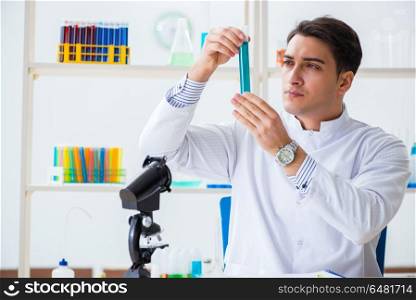 Young chemist student working in lab on chemicals