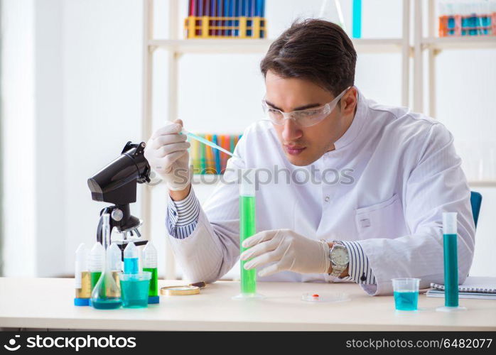 Young chemist student working in lab on chemicals