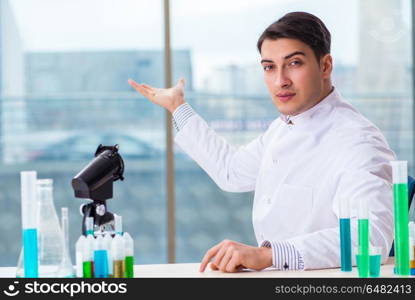 Young chemist student working in lab on chemicals