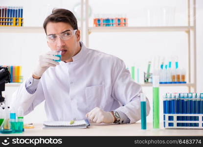 Young chemist student working in lab on chemicals