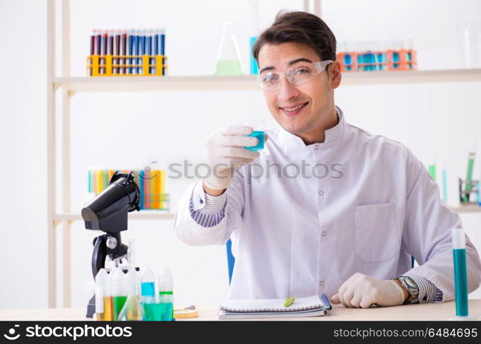 Young chemist student working in lab on chemicals