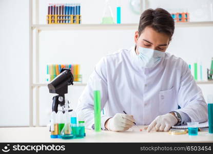 Young chemist student working in lab on chemicals