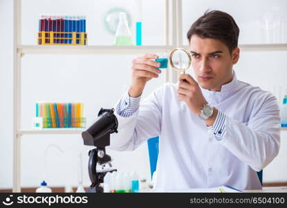 Young chemist student working in lab on chemicals