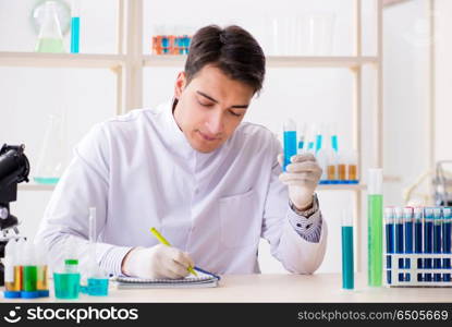 Young chemist student working in lab on chemicals