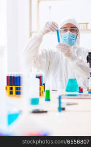 Young chemist student working in lab on chemicals