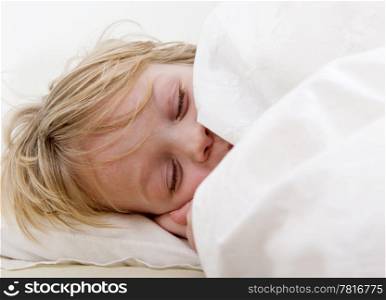 Young child, being sound a sleep, tucked in under his duvet