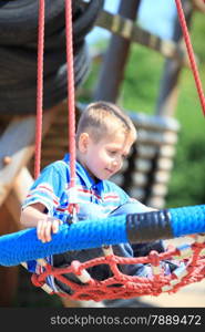 young child boy or kid playing in playground on leisure equipment