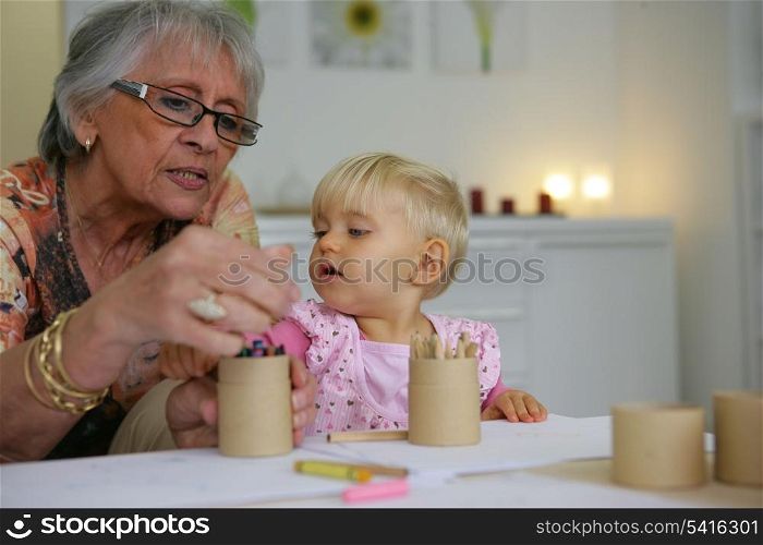 Young child coloring with grandma