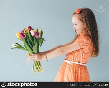 Young child holding a bunch of freshly cut flowers. Celebrating a birthday. Young child holding a bunch of fresh flowers