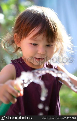 Young child playing with a hose