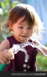Young child playing with a hose