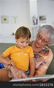 Young child reading with grandma