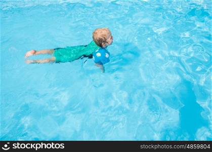 Young child swimming with arm bands
