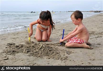 young children are playing on the beach