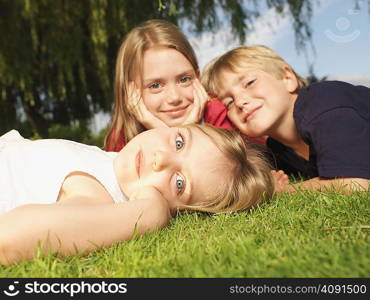 Young children lying on grass, close up