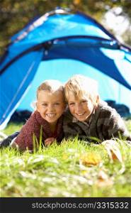 Young children pose outside of tent