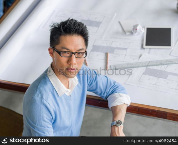 Young chineese engineer working in office. Getting your house plan ready