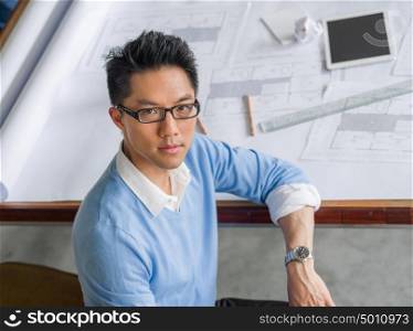 Young chineese engineer working in office. Getting your house plan ready