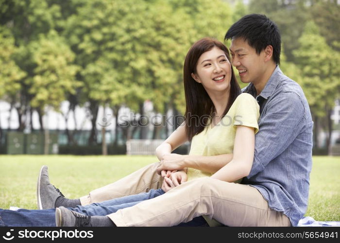 Young Chinese Couple Relaxing In Park Together