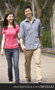 Young Chinese Couple Walking In Park