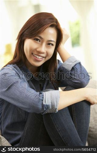 Young Chinese Woman Relaxing On Sofa At Home