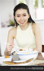 Young Chinese Woman Sitting At Home Eating Meal
