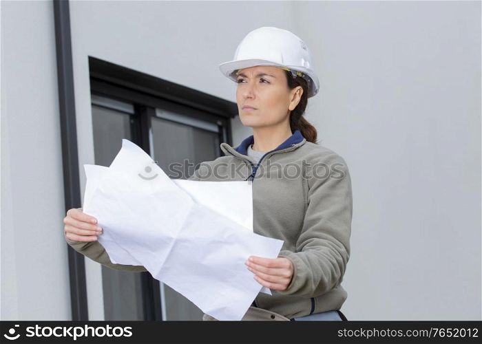 young civil engineer holding paper blueprint