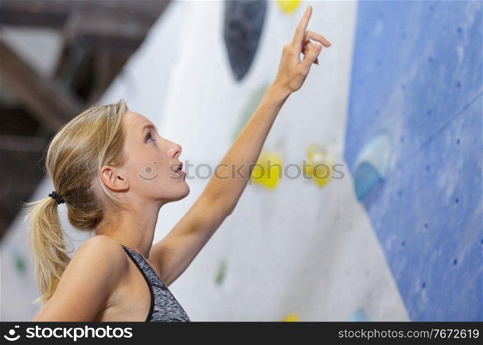 young climber pointing at wall