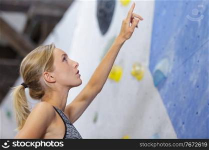 young climber pointing at wall
