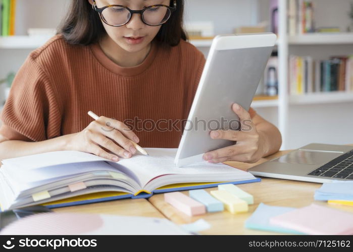 Young collage student using computer and mobile device studying online. Education and online learning.