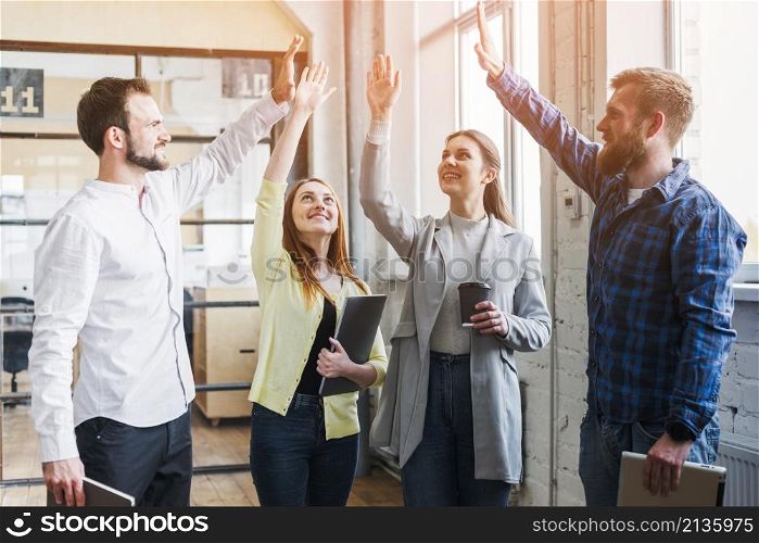 young colleagues giving high five each other