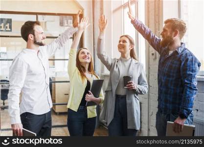 young colleagues giving high five each other