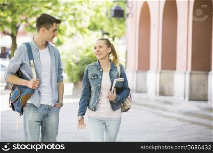 Young college friends talking while walking at campus