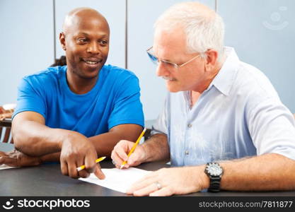 Young college student tutoring an older classmate.