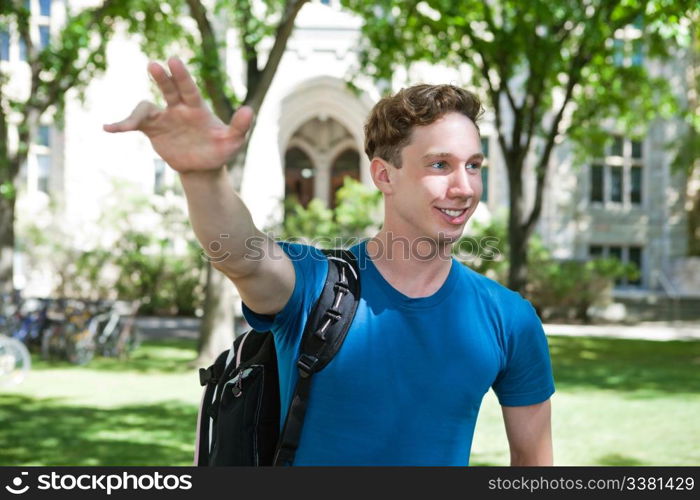 Young college student waving his hand