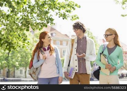 Young college students talking while walking on street