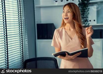 Young competent office lady, intern, secretary holding a log in office room. Concept of various career for office working. Concept of diverse office careers.. Young competent office lady, intern, secretary holding a log in office room.