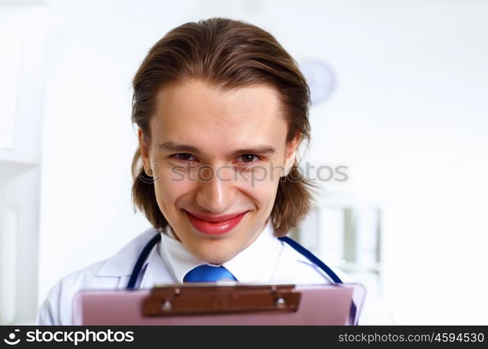 Young confident and friendly doctor in medical office