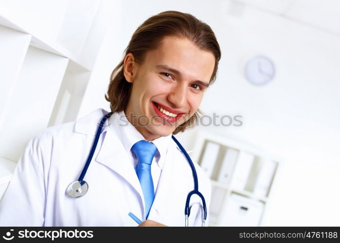 Young confident and friendly doctor in medical office