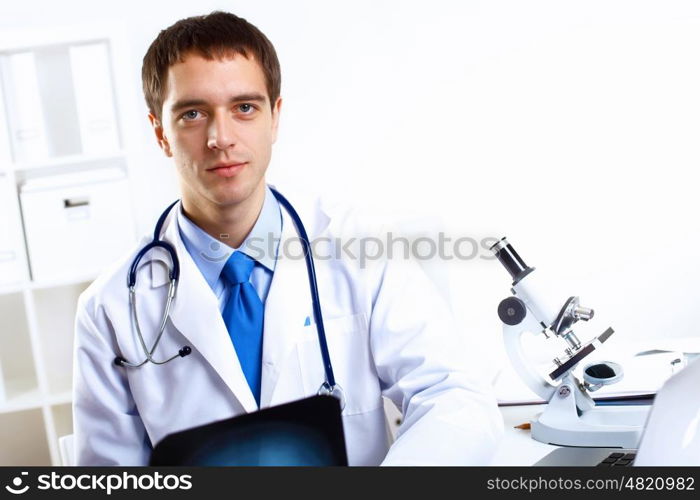 Young confident and friendly doctor in medical office