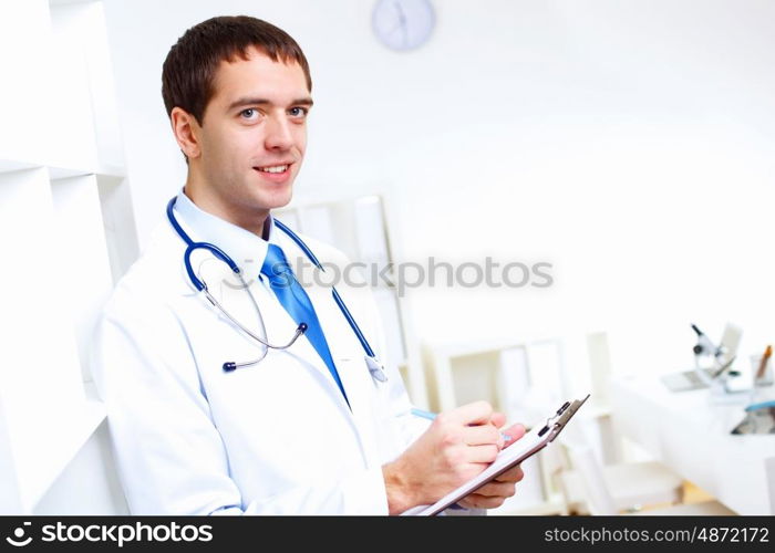 Young confident and friendly doctor in medical office