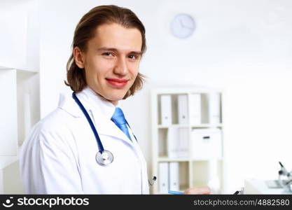 Young confident and friendly doctor in medical office