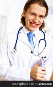 Young confident and friendly doctor in medical office